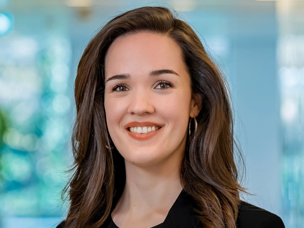 Portrait of Lisa Verhoeven, Business Generation Manager, in an office against a blue glass background