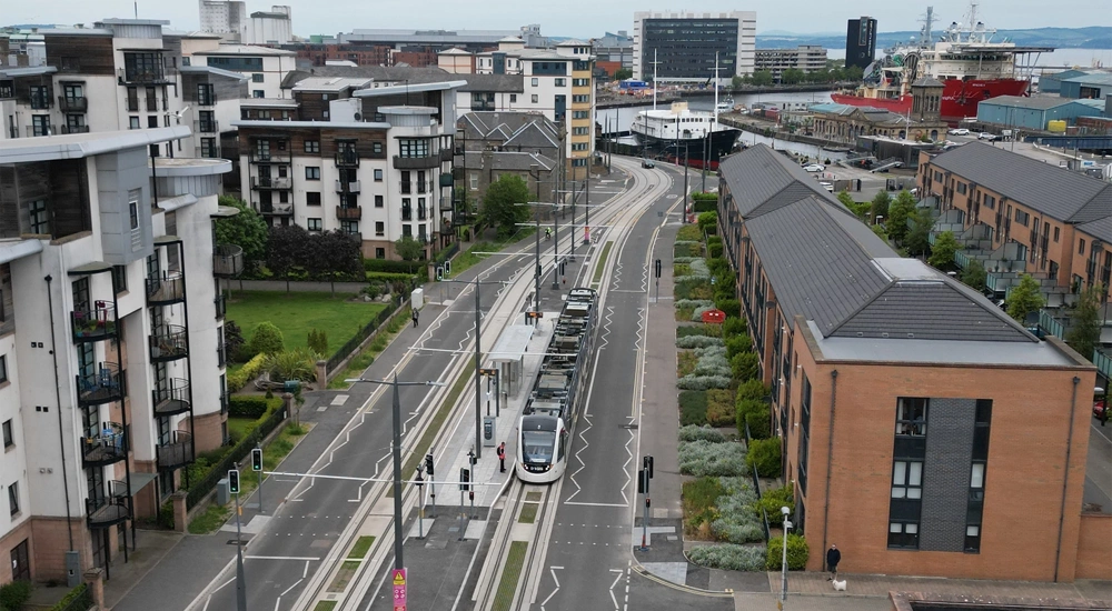 Aerial of tram travelling through residential area, Edinburgh, Scotland