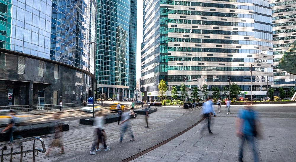 Pedestrians walking surrounded by high rise glass office buildings
