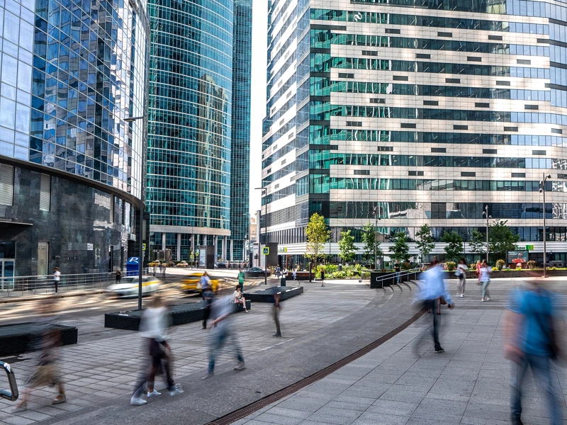 Pedestrians walking surrounded by high rise glass office buildings