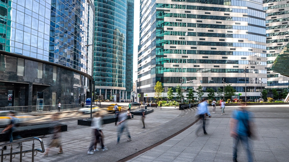 Pedestrians walking surrounded by high rise glass office buildings