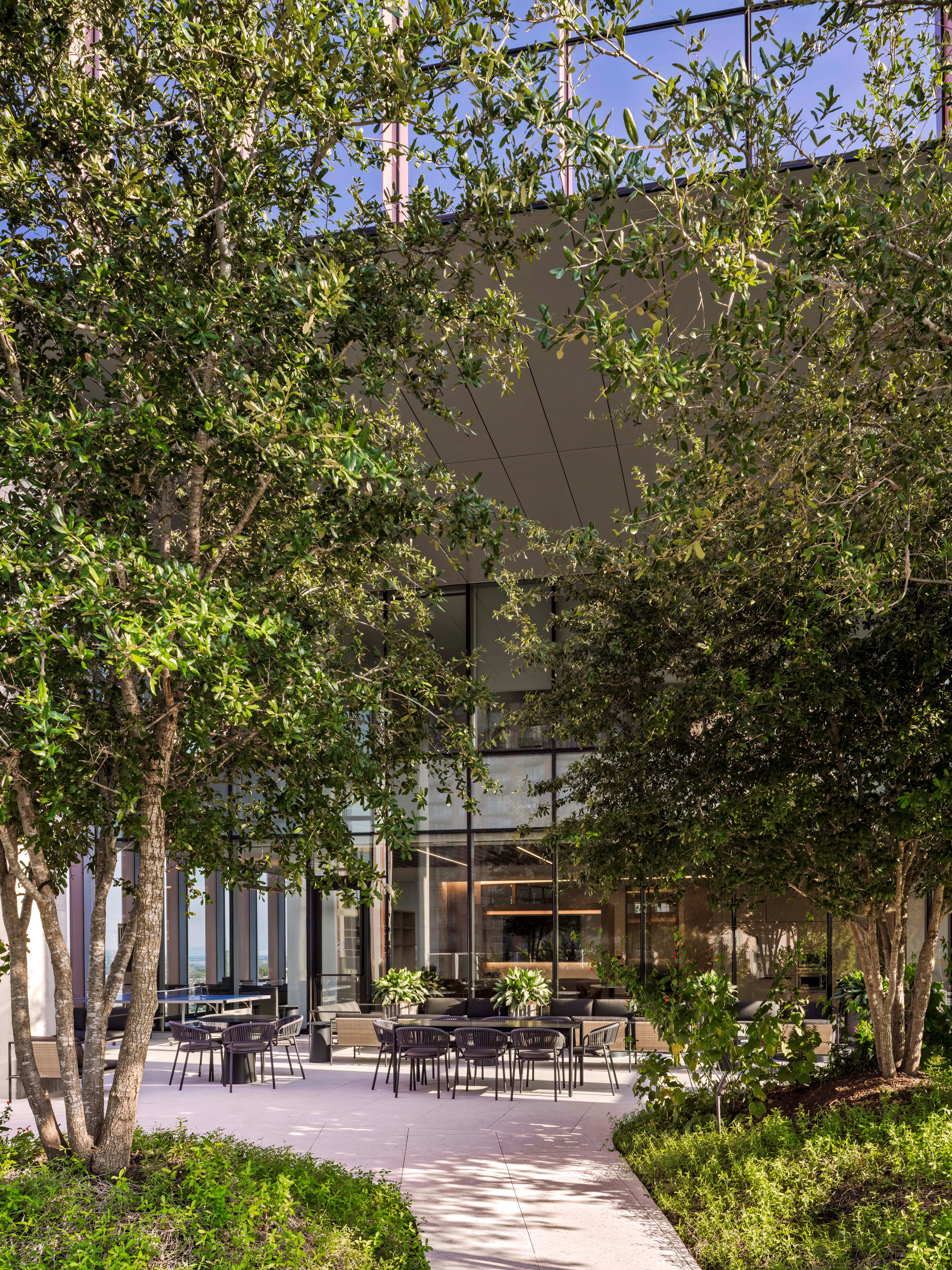 A modern office in the daytime, outdoors with lots of sunlight and trees