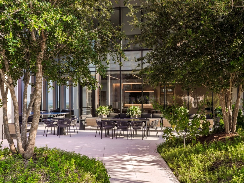 A modern office in the daytime, outdoors with lots of sunlight and trees