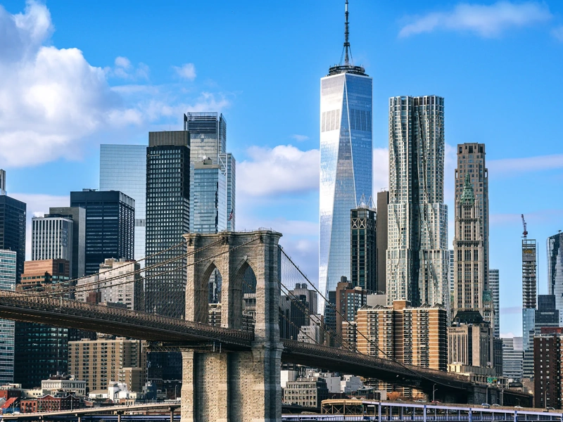 Iconic view featuring the Brooklyn Bridge against the modern New York City skyline on a clear day, showcasing the city's architectural beauty and urban energy.