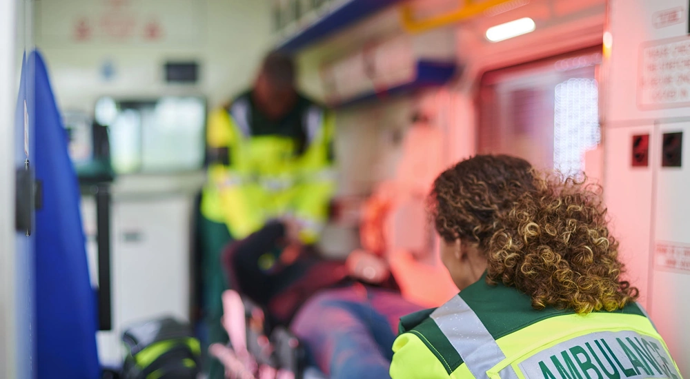 Interior of ambulance with two medics professionals and a patient on a stretcher