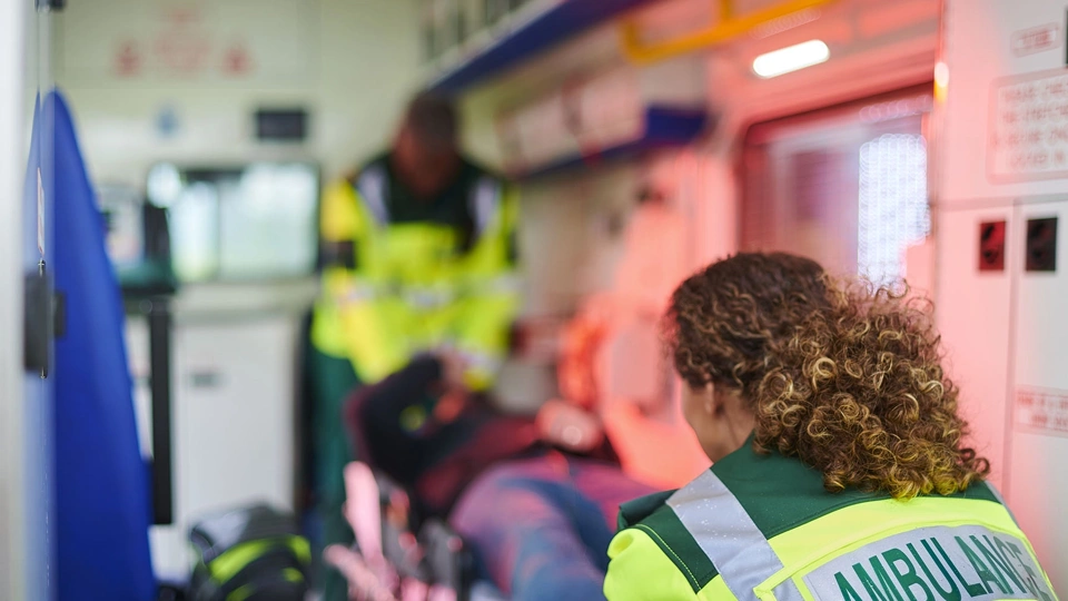 Interior of ambulance with two medics professionals and a patient on a stretcher