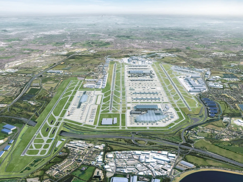 Ariel CGI masterplan of Heathrow airports 2026 expansion, showing multiple parallel runways, large terminal buildings, taxiways, surrounding roads and nearby water reservoirs.