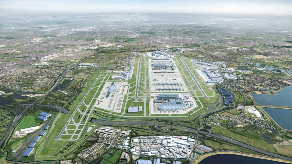 Ariel CGI masterplan of Heathrow airports 2026 expansion, showing multiple parallel runways, large terminal buildings, taxiways, surrounding roads and nearby water reservoirs.