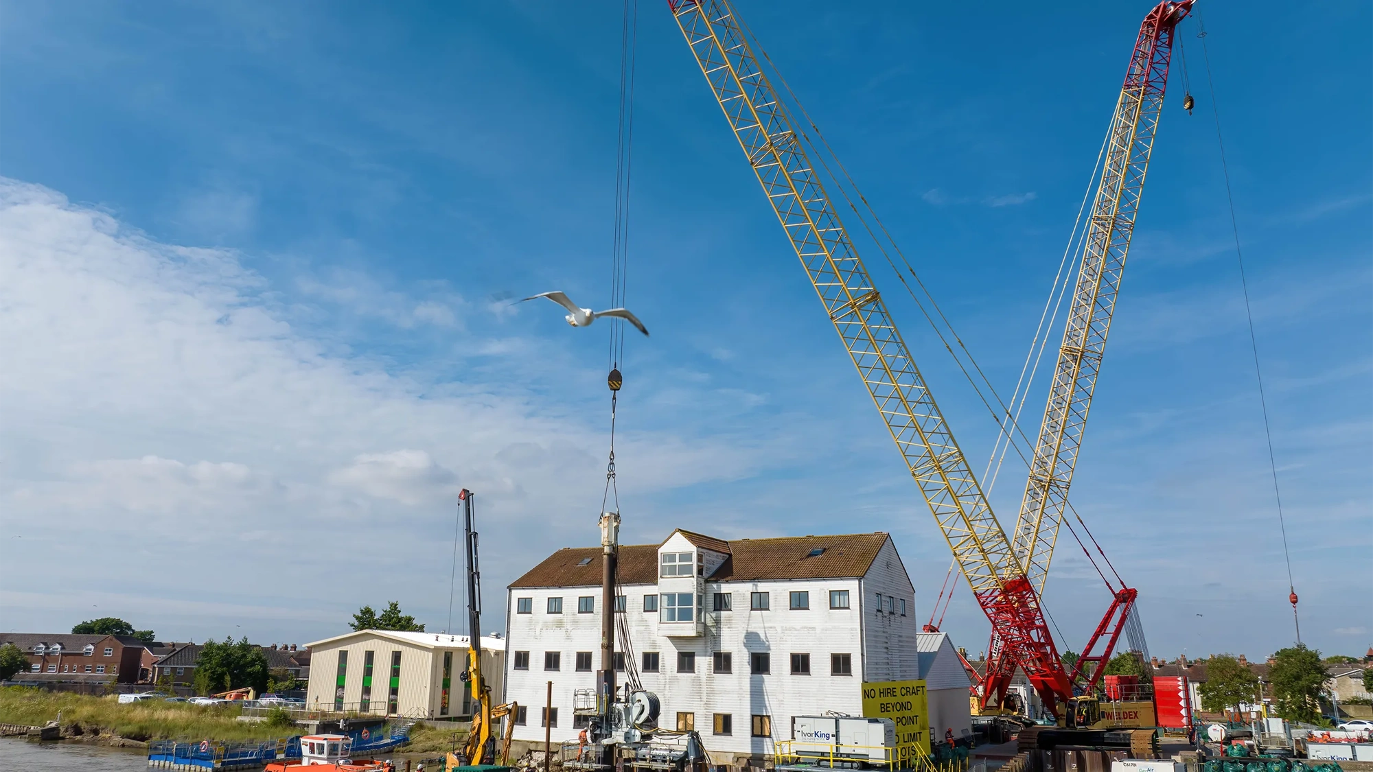 White house with blue sky with a crane in front of it.