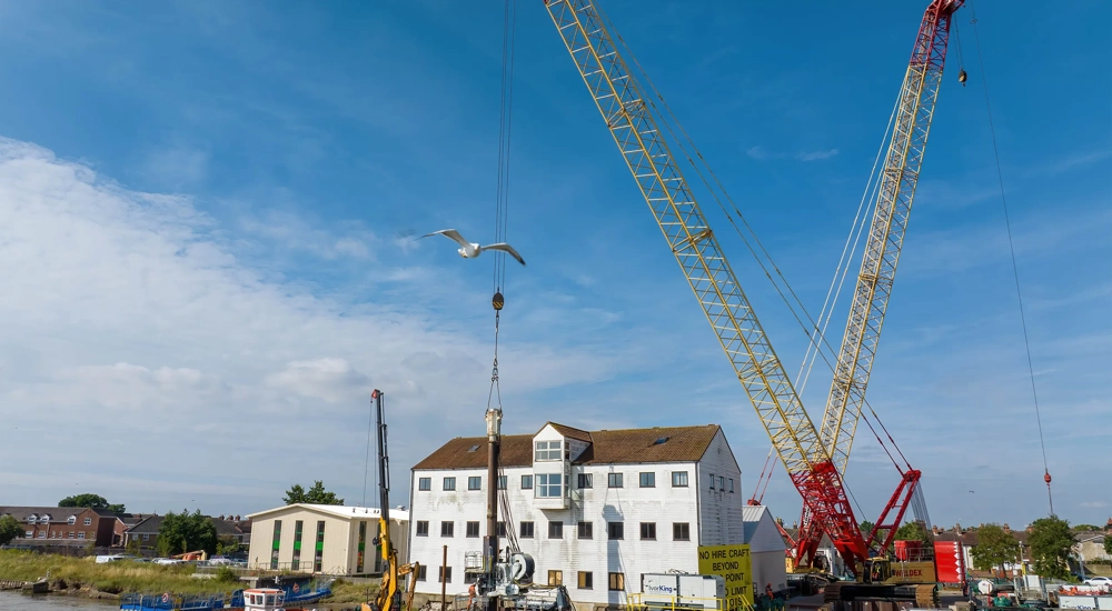 White house with blue sky with a crane in front of it.