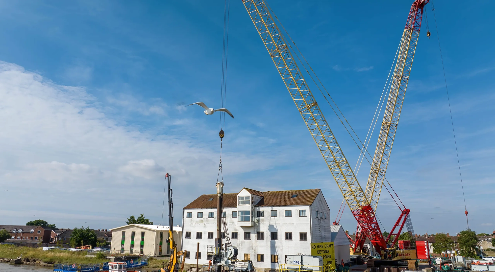 White house with blue sky with a crane in front of it.