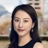 Kexin Sun outside in front of a blurred brown background featuring a building and mix of natural and urban elements.