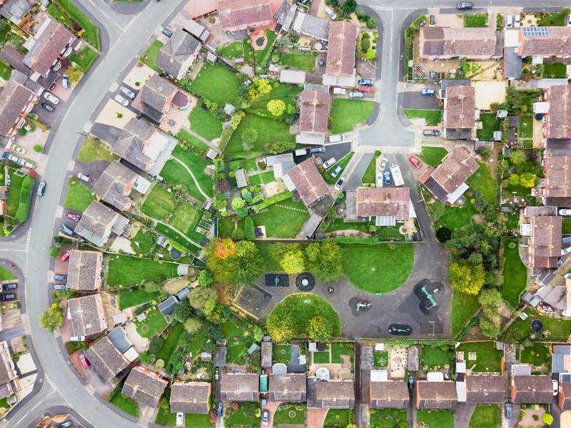 Aerial view of houses in a village, showing street layout and gardens