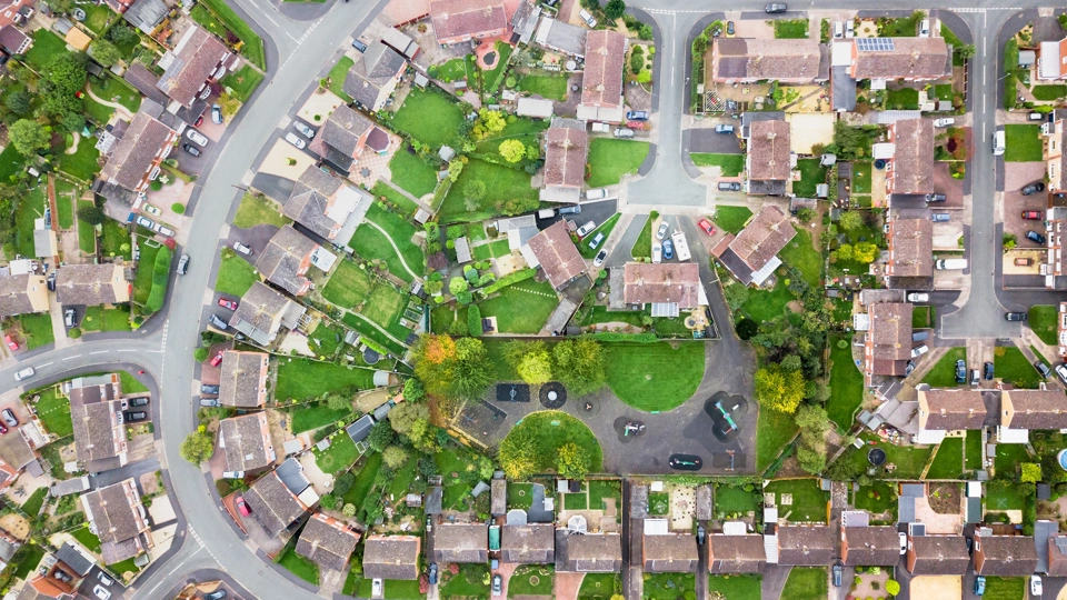 Aerial view of houses in a village, showing street layout and gardens