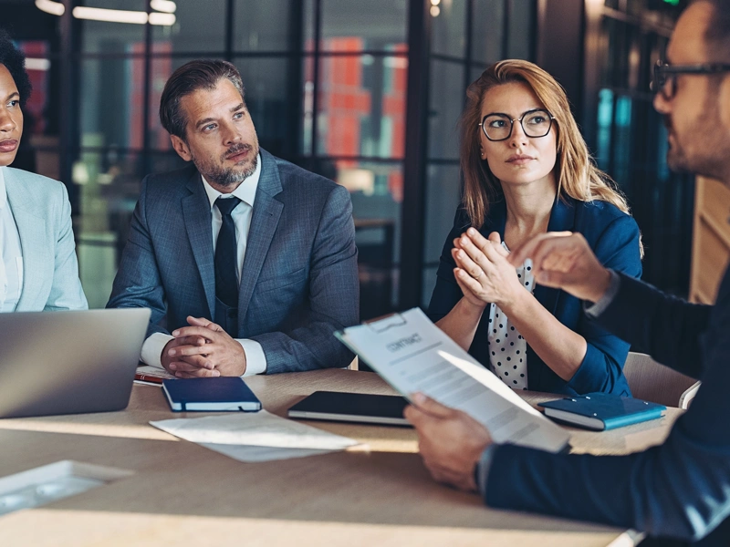 Four colleagues sat at a table in a meeting