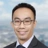 Portrait of Johnson Zi hao Chua, Head of Project Management, Singapore, outside in front of tall city buildings with blue skies.