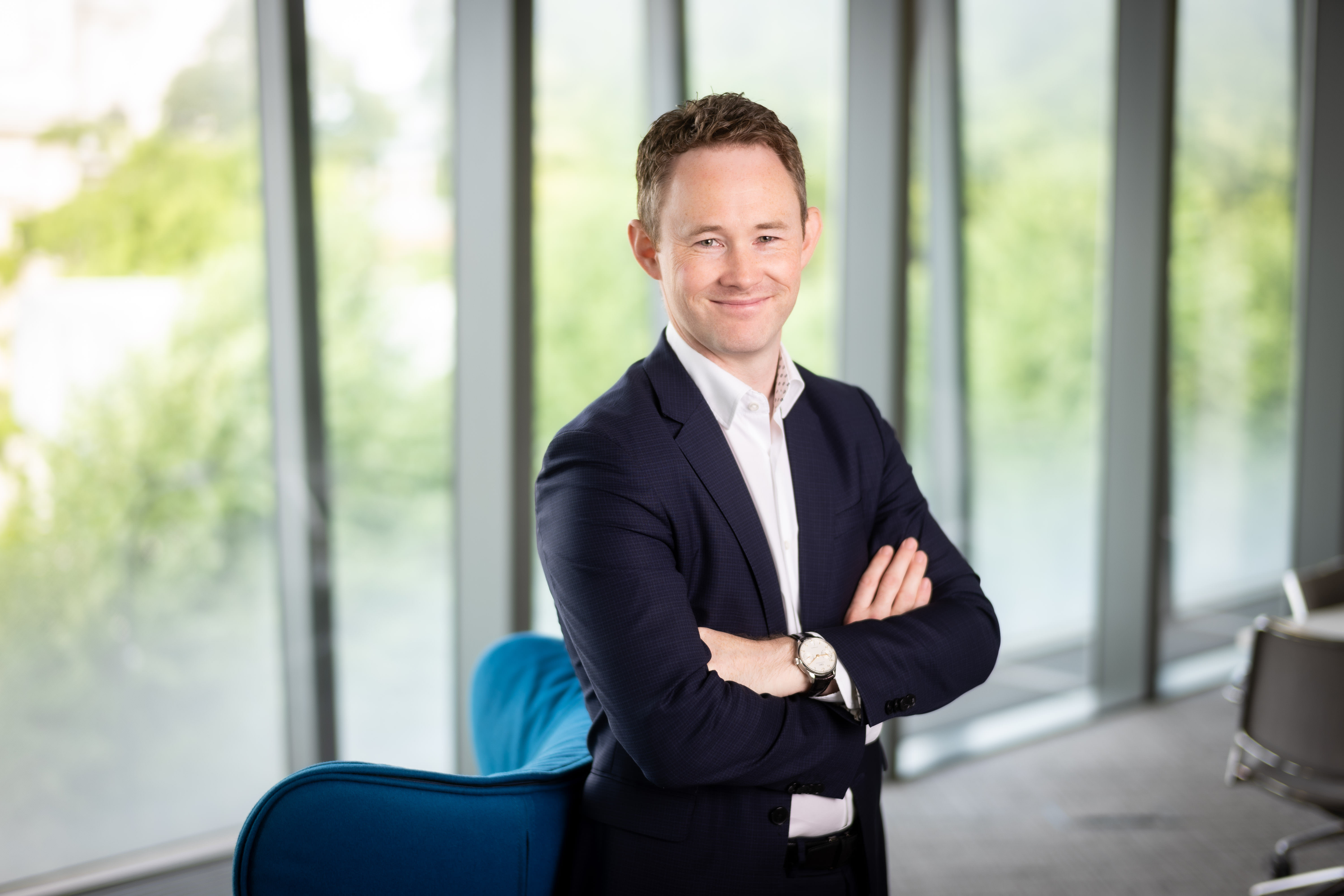 David Whysall, Global Managing Director of Energy and Natural Resources, smiling with his arms folded in an office with windows