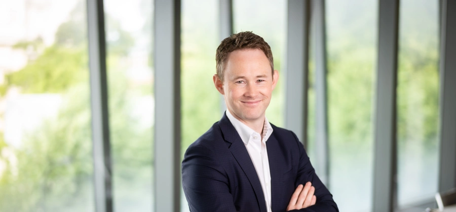 David Whysall, Global Managing Director of Energy and Natural Resources, smiling with his arms folded in an office with windows