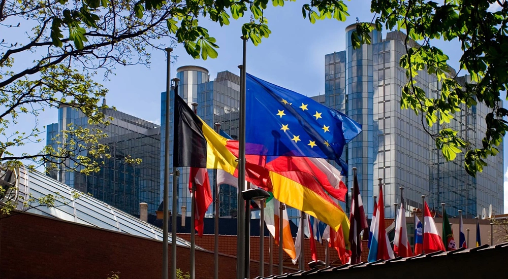 The European union flag with the flags in the European union behind it in a line