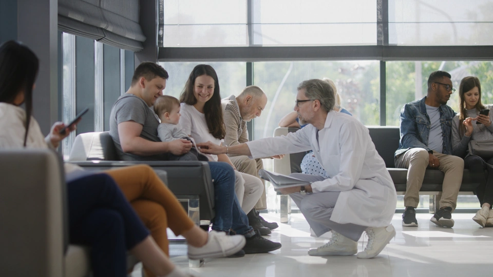 Doctor speaking to couple with baby in hospital