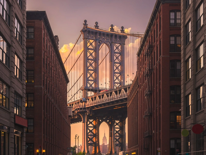 New York city street view with bridge and Empire State Building in the far distance