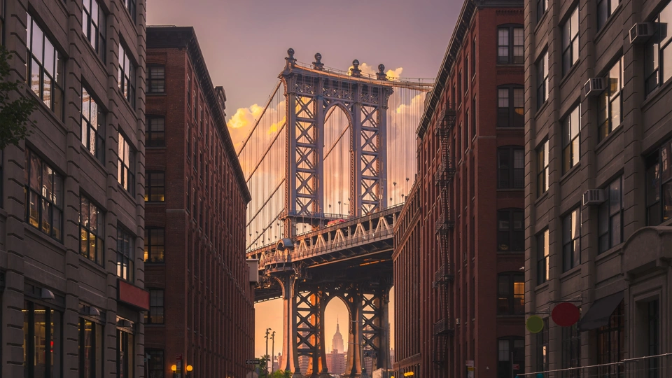 New York city street view with bridge and Empire State Building in the far distance