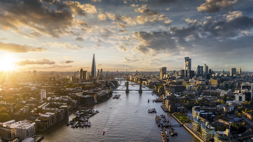 View of London landmarks such as the London bridge and River Thames with the sun beaming down on the view of London
