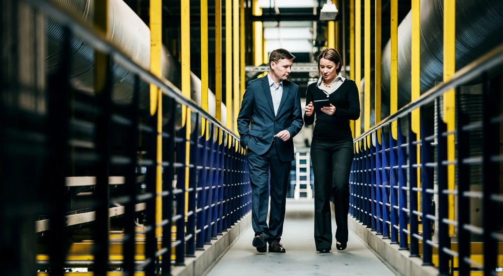Two professionals walking through a factory