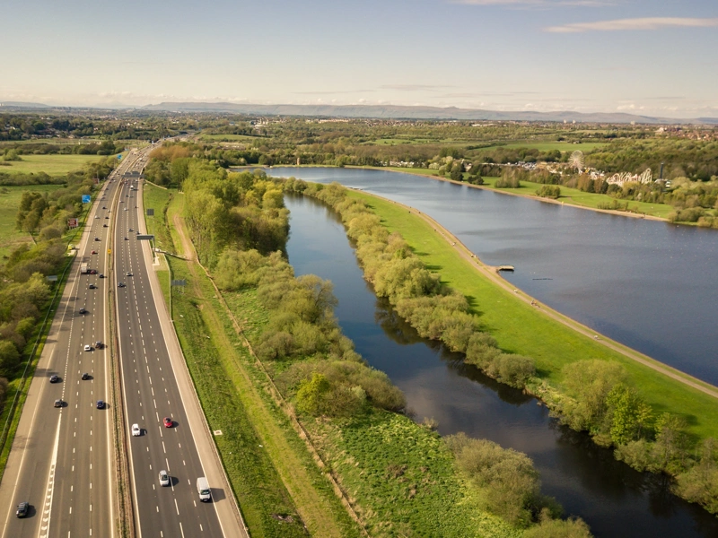 Motorway alongside greenery and water