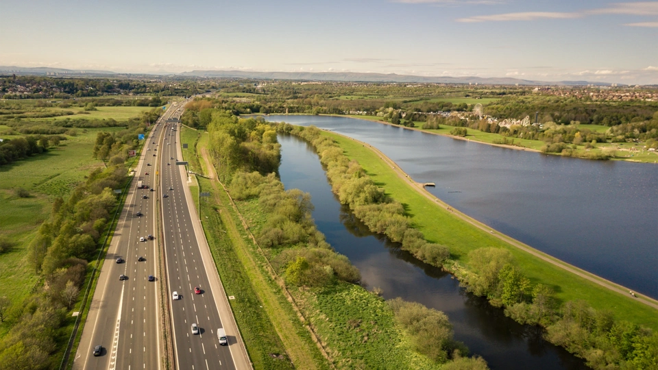 Motorway alongside greenery and water