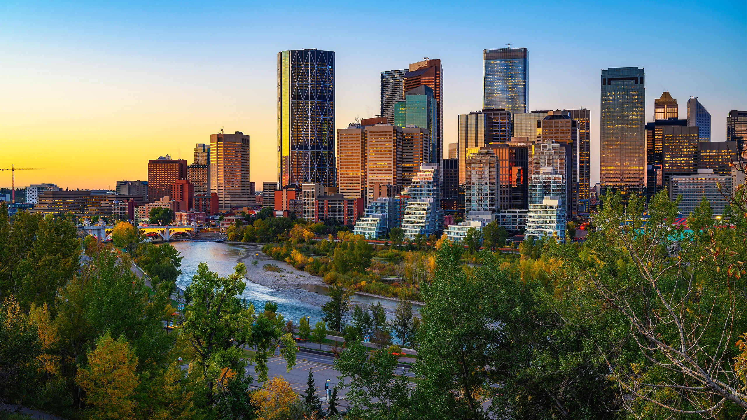 Canada skyline with buildings in the background and a river in the foreground, at sunset
