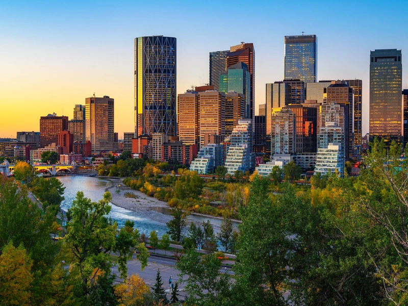 Canada skyline with buildings in the background and a river in the foreground, at sunset