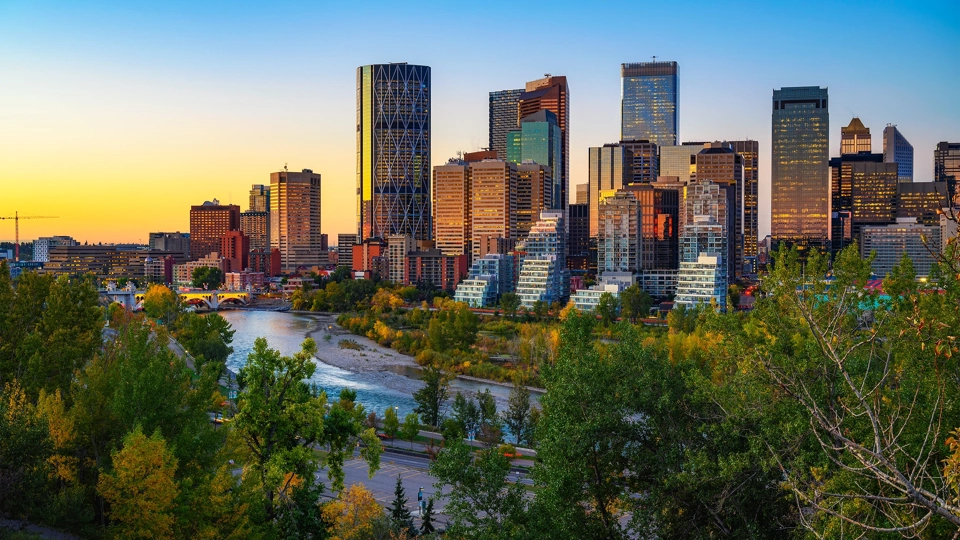 Canada skyline with buildings in the background and a river in the foreground, at sunset