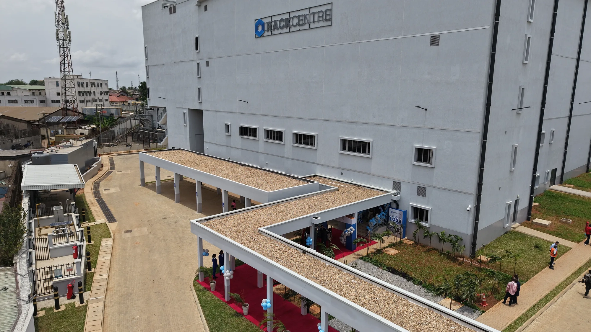 Ezteror view of Rack Centre, large industrial building with a covered walkway and people walking nearby.