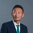 Portrait of Kajiura Hisanao, Managing Director, Japan, in blue suit against dark blue/grey background.