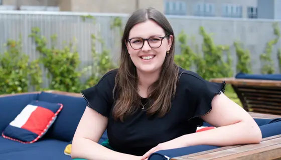 Director, Sustainability, US, Imogen Large, outside on armchair in front of trees