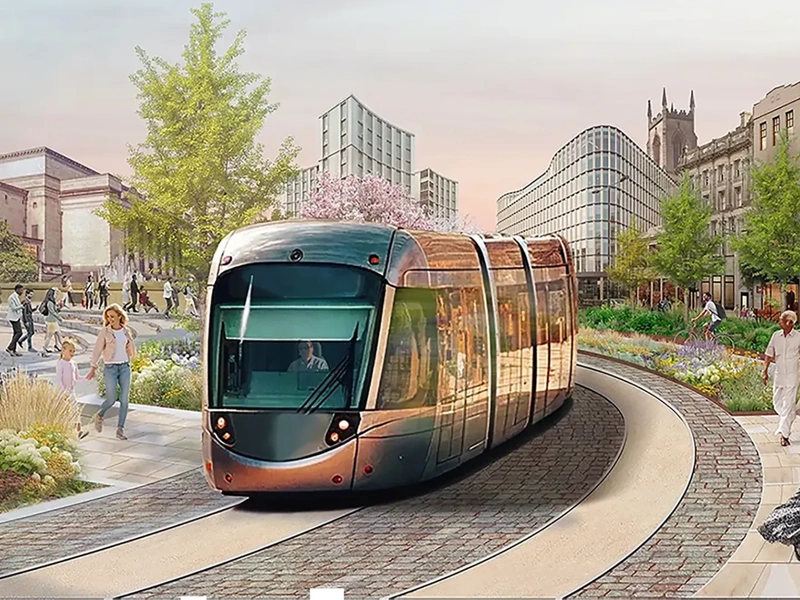 A modern train travels along a curved track in a vibrant urban setting. The surrounding area features beautifully landscaped gardens with colourful flowers and trees. Pedestrians are walking and enjoying the scenery, and a couple is seen riding bicycles. The background showcases a mix of historical and contemporary buildings, including a church with a tall spire. The scene is lively, with people engaging in various activities, reflecting a harmonious blend of nature and urban life.