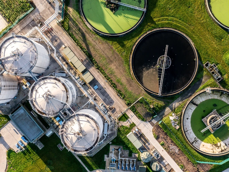 An aerial view directly above a waste water treatment works with circular storage tanks filtering wastewater for drinking water