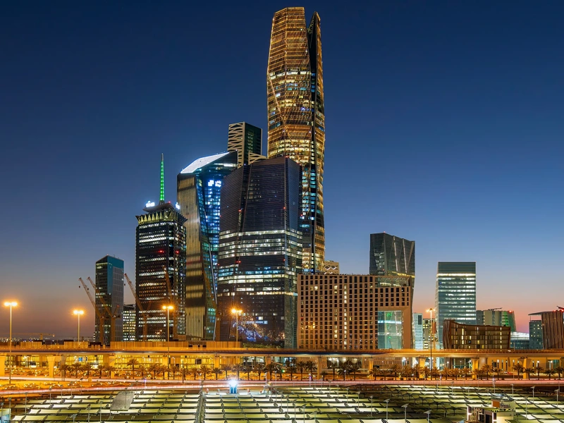 Aerial view of Riyadh at night with illuminated modern skyscrapers and busy streets under a clear dark sky, Al Olaya street