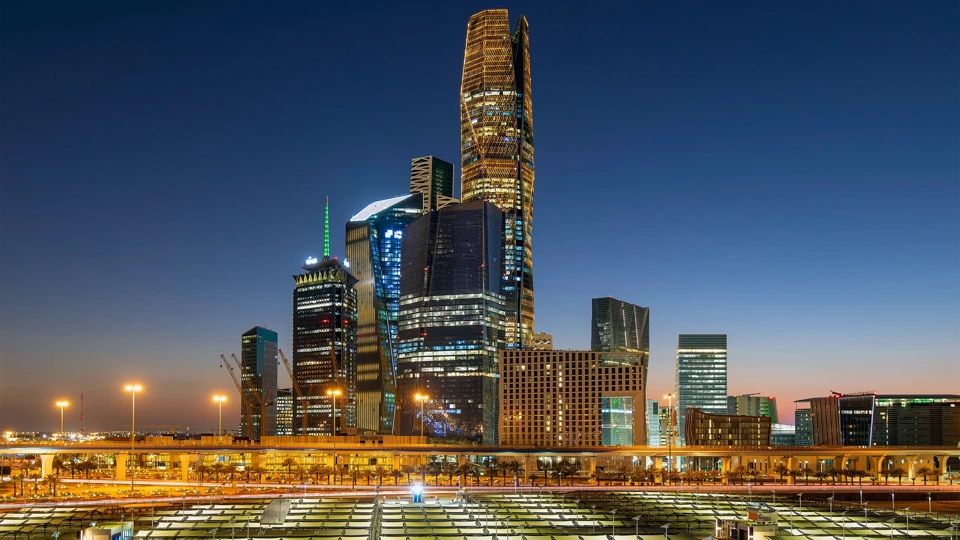 Aerial view of Riyadh at night with illuminated modern skyscrapers and busy streets under a clear dark sky, Al Olaya street