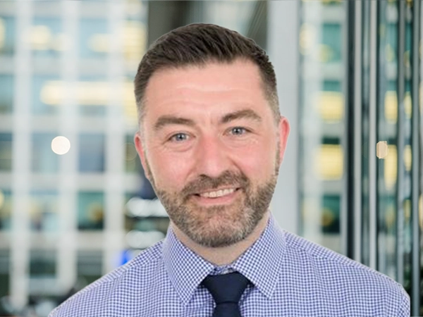 Portrait of Ewan Carmichael, Director, Technical Lead Performance Forum, Edinburgh, standing in window based office building.