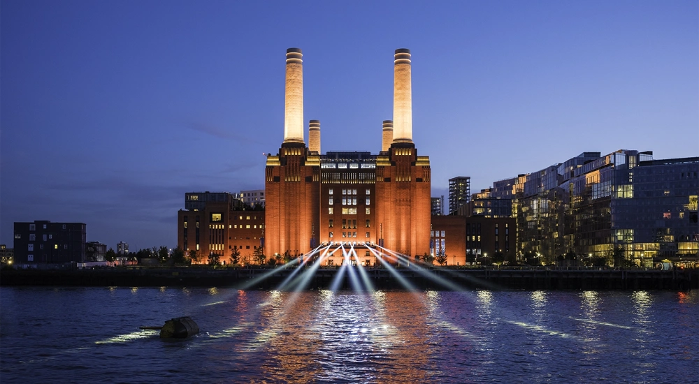 Battersea Power Station illuminated at night, viewed from across the River Thames, London, UK