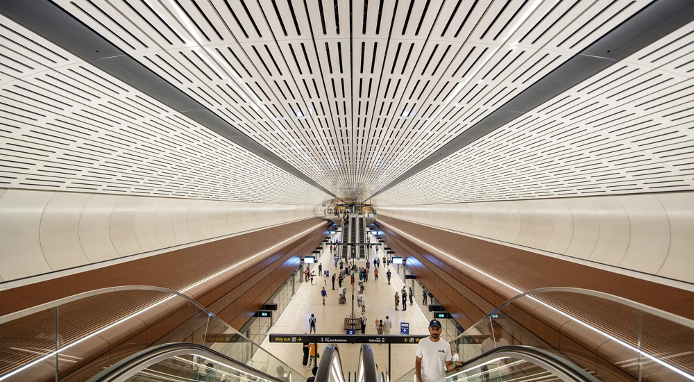 Interior of Sydney metro modern station with white, ventilated cieling and beige tiled floor, Australia