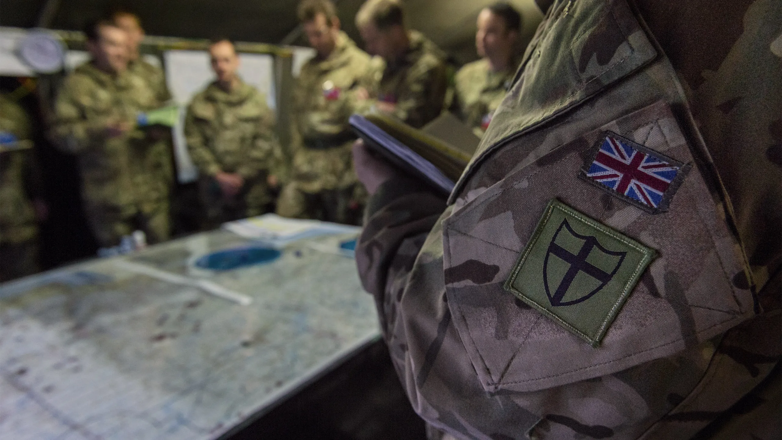 Close up of British Army camouflage uniform with the Union Jack flag sewn on the pocket.