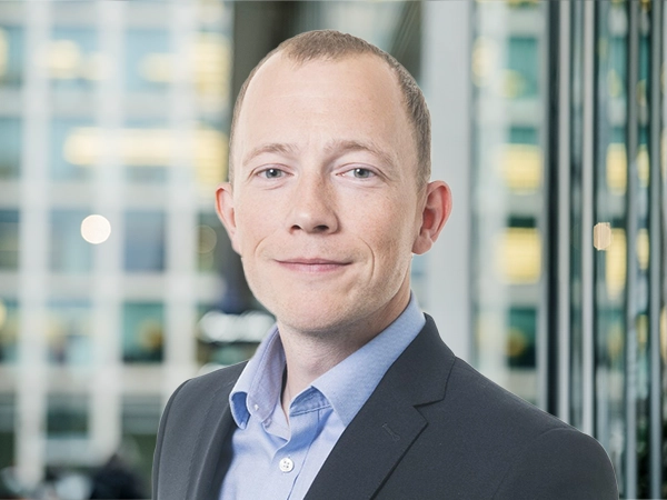 Portrait of Luke Pardoe, Project Director, standing in window based office building.