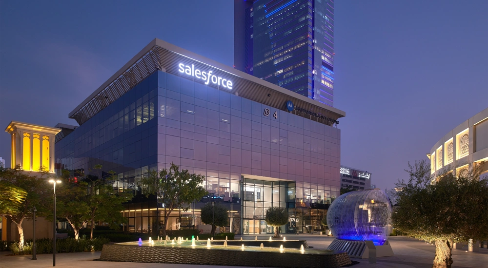 Image of Dubai Salesforce office at night, glass windows that reflects the purple ambiance of the night sky.
