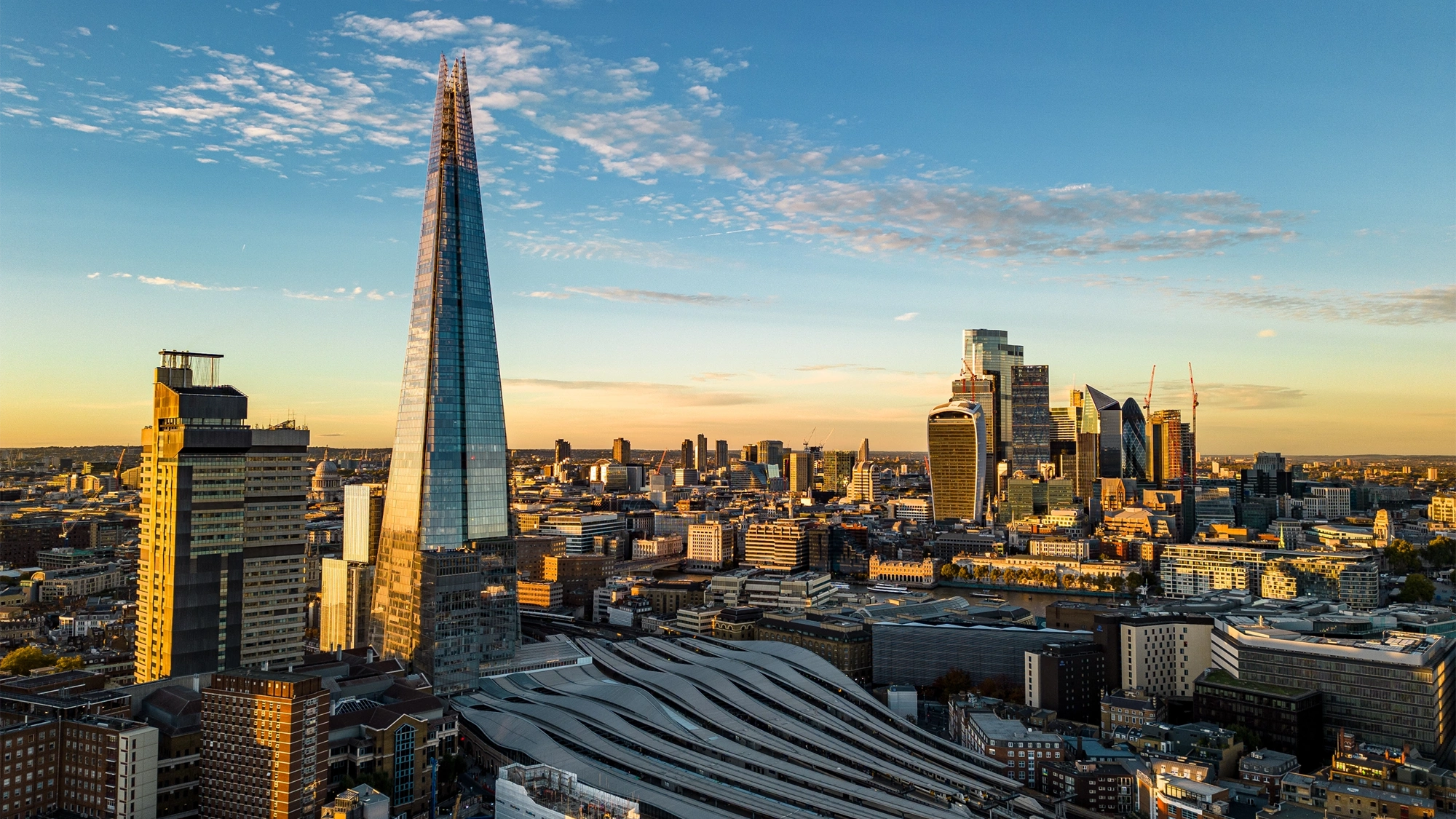 Skyline view of London buildings during sunrise, featuring the shard.
