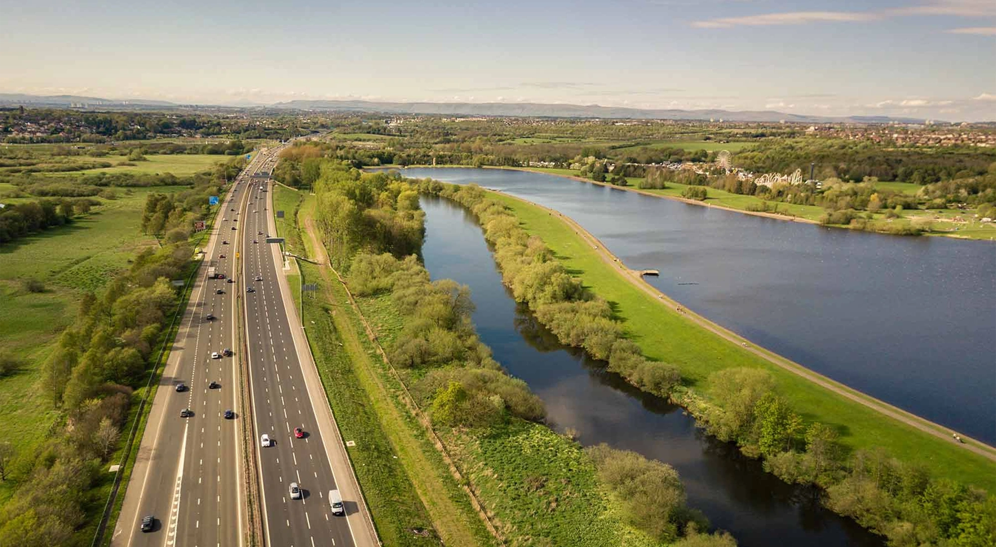 View of a motorway with greenery surrounding the motorway.