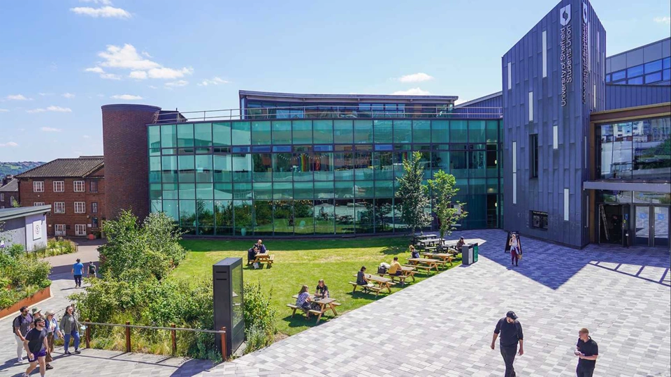 University of Sheffield’s student union, a modern building with students roaming the courtyard in front