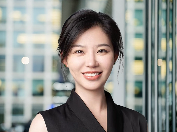 Jennifer Zhu in modern office, with glass panels, and a softly blurred workspace behind.